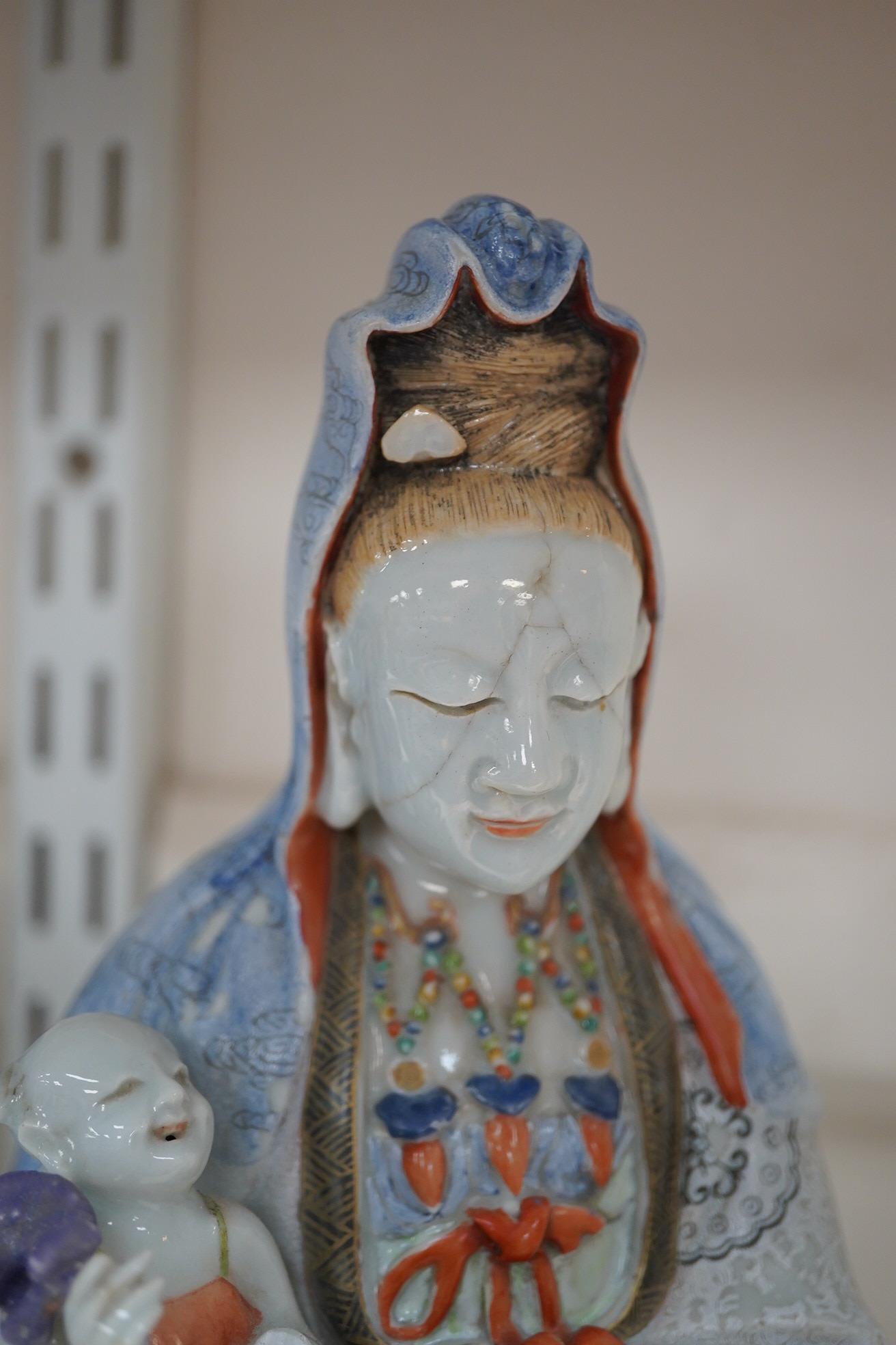 A Chinese enamelled porcelain group of Guanyin holding a child, Qianlong period